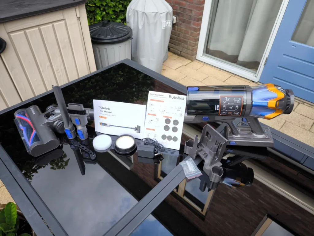 Inhoud van de verpakking van de Bulelink Zenith G10 steelstofzuiger met alle accessoires op zwarte tafel buiten.